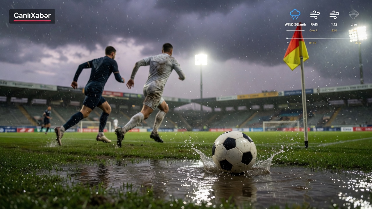 Rain-soaked football scene at dusk: a ball splashes across a wet pitch, wind bends